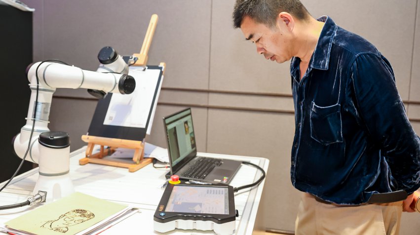 嘉賓體驗遨博AI繪畫機(jī)器人。主辦方供圖